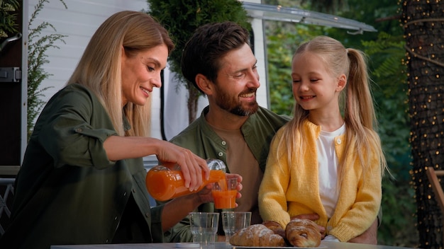 Kaukasische familie op kampeervakantie buiten zitten in de buurt van busje lunchen picknicken eten goed mee