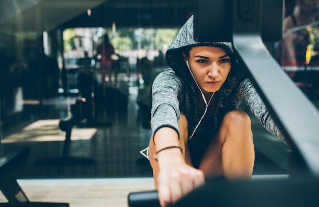 Kaukasische fit brunette vrouw doet oefeningen voor benen in de sportschool sportieve vrouw trainen met barbell in de sportschool Fitness bodybuilding mensen gezonde levensstijl en sport concept Kopieer ruimte