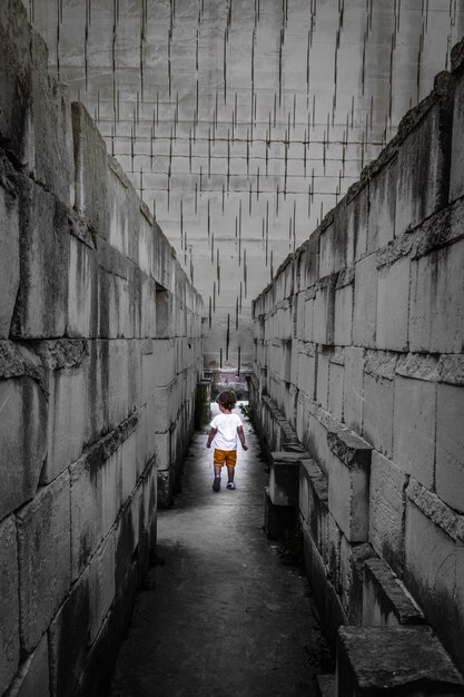 Kaukasische jonge jongen wandelen met labyrint perspectief. Conceptueel beeld voor gevaarlijke situatie tijdens de kindertijd.