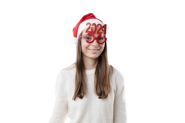 Kaukasische jonge mooie vrouw met rode kerstmuts en 2021 glazen.