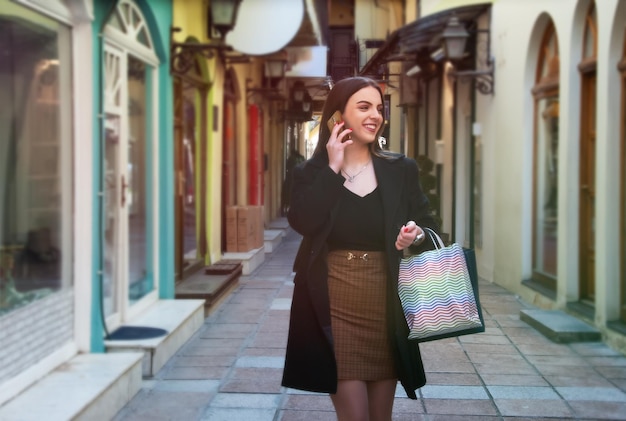 Kaukasische jonge vrouw die buiten loopt met boodschappentassen