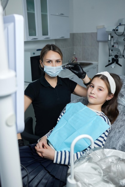 Kaukasische kleine jongen meisje onzichtbare aligner en wijzend naar haar perfecte rechte tanden. Tandheelkundige zorg en vertrouwen concept.