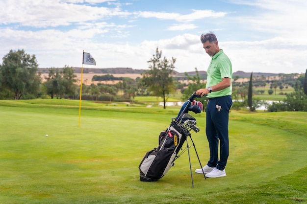 Kaukasische professionele golfspeler op een golfbaan op de green die zich voorbereidt op het schot