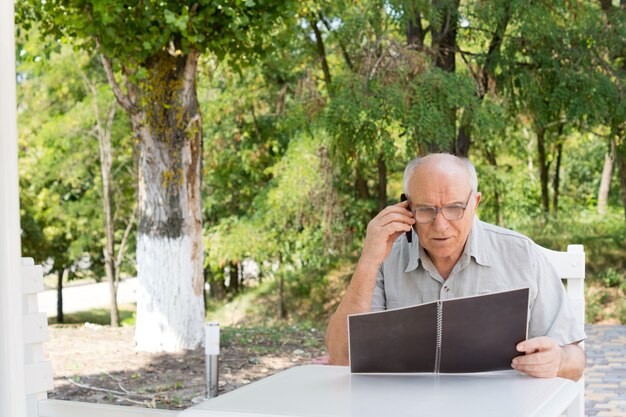 Kaukasische senior man praten over de mobiele telefoon