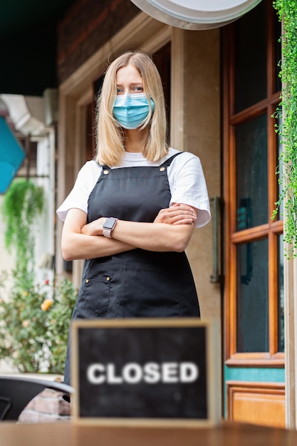 Kaukasische serveerster vrouw met medisch masker cafe gesloten coronavirus covid-19 pandemie