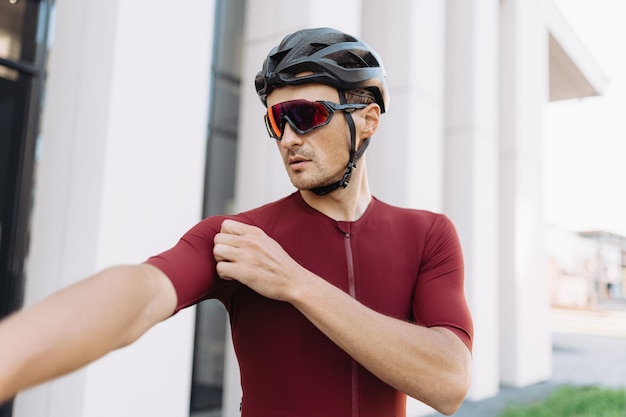 Kaukasische sportman in activewear-helm en bril die zich voorbereidt op langeafstandsfietsen in de straten van de stad Hobbymensen en buitenactiviteitenconcept