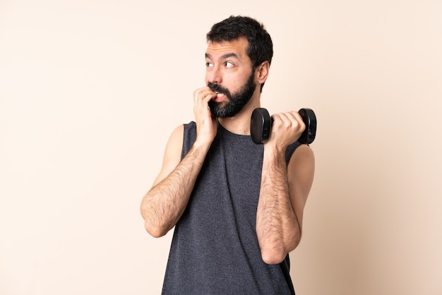 Kaukasische sportmens met baard die gewichtheffen geïsoleerd maken