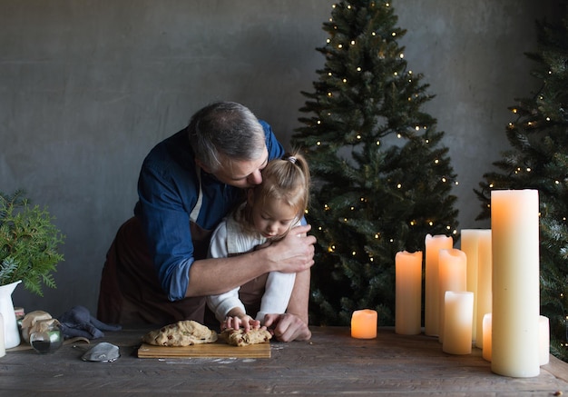 Kaukasische vader en dochter koken koekjesdeeg samen in de keuken Voorbereiding op de viering van Kerstmis