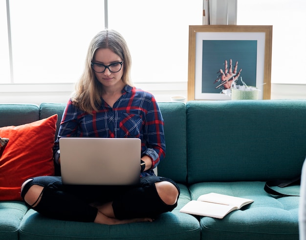 Kaukasische vrouw die computerlaptop op de laag met behulp van