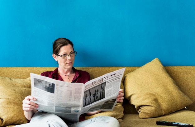 Kaukasische vrouw die de krant leest