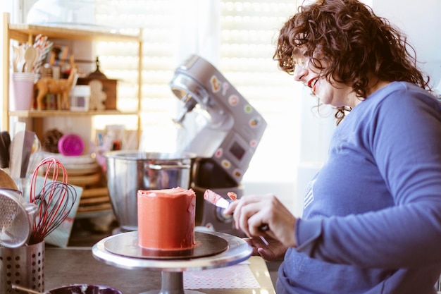 Kaukasische vrouw die een cake in de keuken voorbereidt. Gebak thuis. Selectieve aandacht.