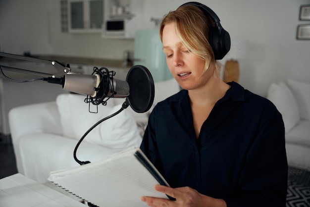 Kaukasische vrouwelijke freelance werker die thuis podcast opneemt