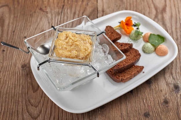 Kaviaar van snoek op een witte plaat met toast en ijs
