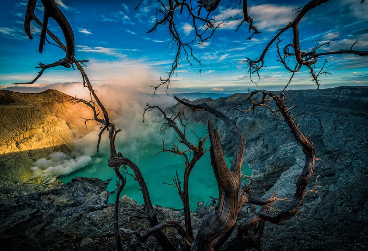 Foto kawah ijen-vulkaan met dode bomen op blauwe hemelachtergrond in java, indonesië.