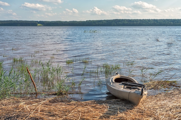 Kayak sulla riva sabbiosa del lago in una luminosa giornata di sole luce naturale