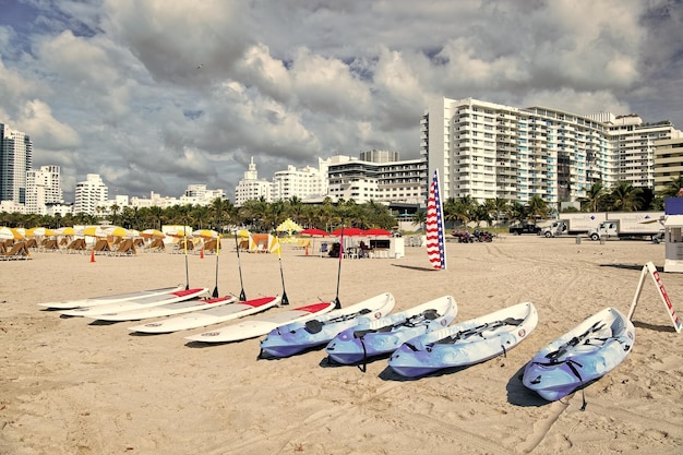 Kayak and surfboards with paddles on sand