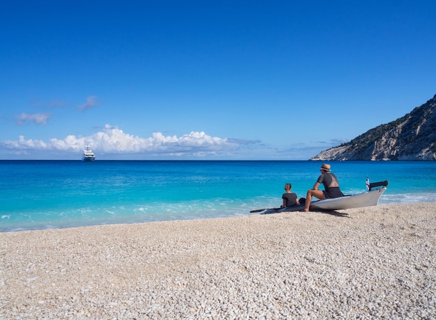 Kayakers on the kayak and a yacht in the background of clouds in the ionian sea in greece