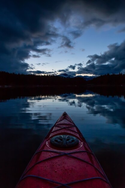 Kayaking in a peaceful and calm glacier lake during a vibrant cloudy sunset