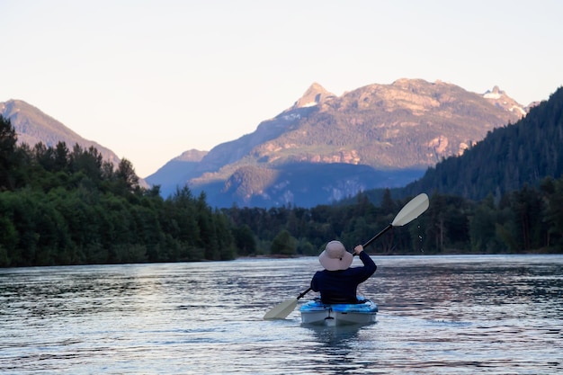 Kayaking in a river surrounded by Canadian Mountains