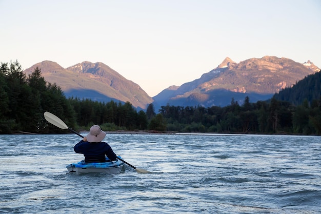 Kayaking in a river surrounded by Canadian Mountains