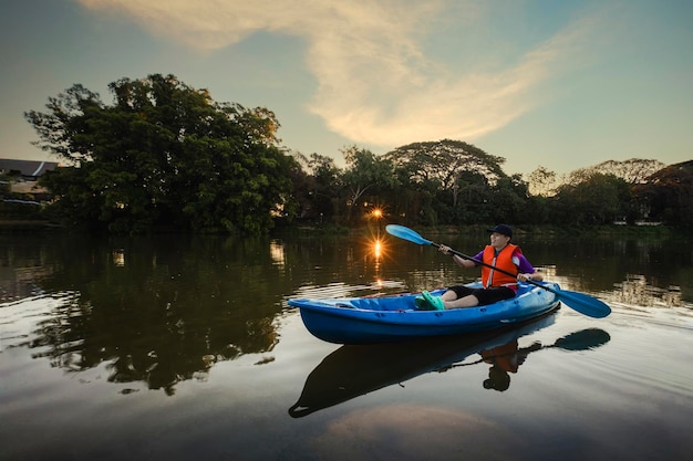 Kayaking water sports with copy space Young Kayaker man in a beautiful lake during sunrise in the morning