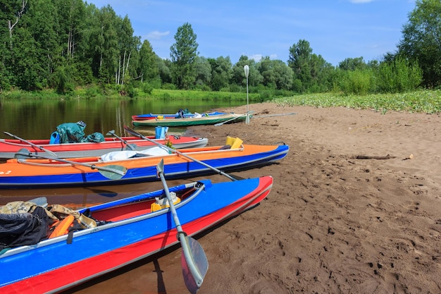 Kayaks on the shore of a river