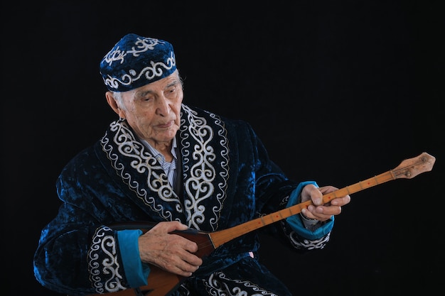 Photo kazakh old man playing dombra