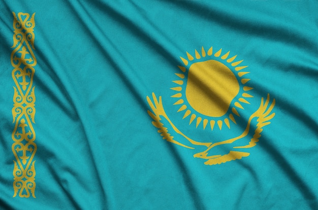 Фото Флаг казахстана изображен на спортивной ткани с множеством складок.