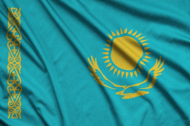 Kazakhstan flag  is depicted on a sports cloth fabric with many folds.