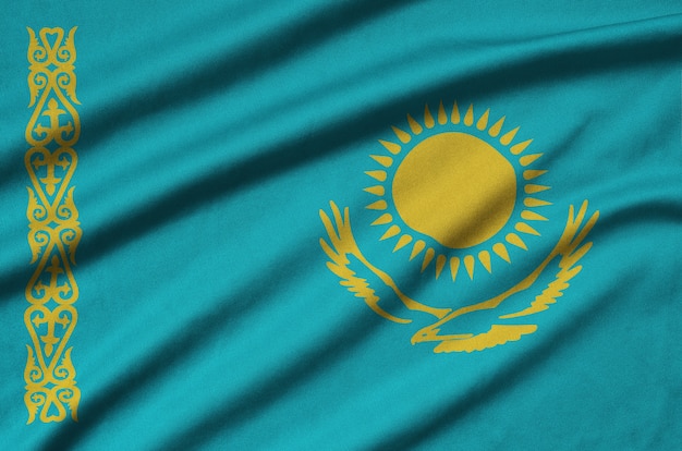 Kazakhstan flag is depicted on a sports cloth fabric with many folds.