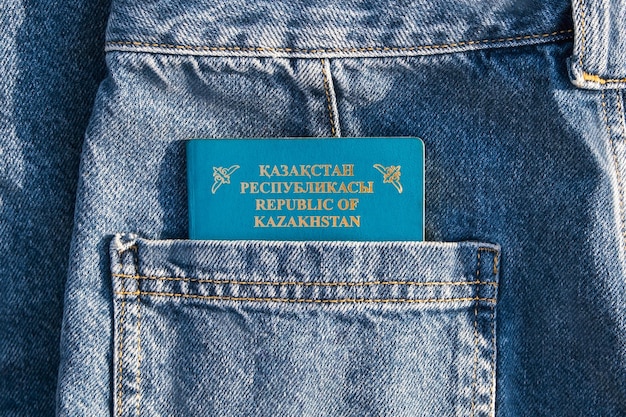 Foto primo piano del passaporto del kazakistan in una tasca posteriore dei jeans blu documento del passaporto kz