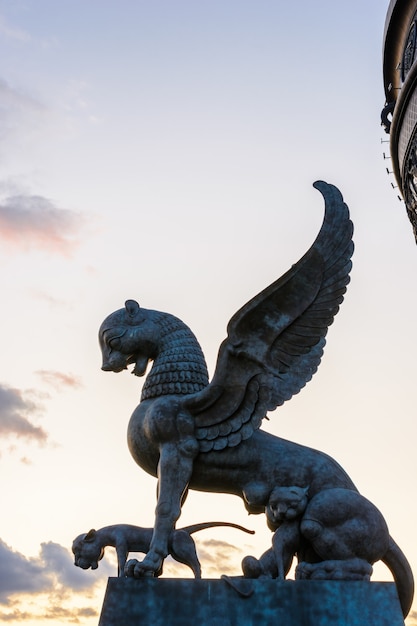 사진 카잔, 타타르스탄, 러시아 - 2019년 9월 28일. 날개 달린 눈표범(ak bars, aq bars)의 조각상 암컷, 카잔 결혼식 궁전 근처 타타르스탄의 상징인 새끼와 함께. 일몰.