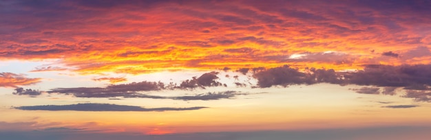 사진 다채로운 구름이 있는 하늘을 배경으로 극적인 해가 뜨고 새가 없는 해가 지는 큰 파노라마 사진 이것은 진정한 천국입니다.