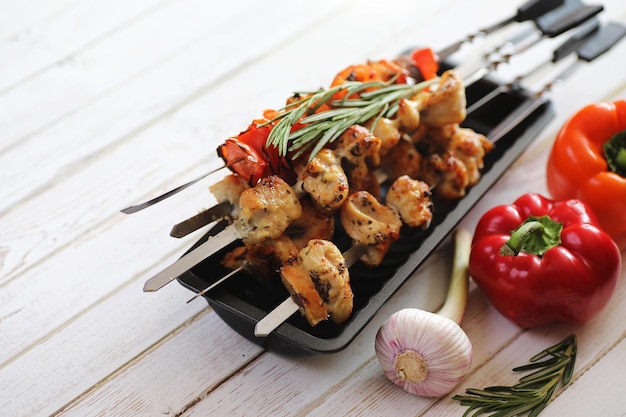 Photo kebab cooked on metal skewers with vegetables