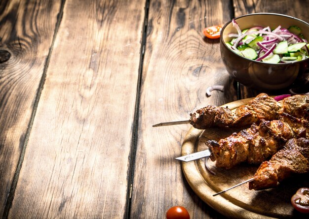 Kebab with fresh salad of cucumbers and onions.