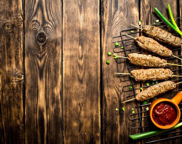 Kebab with tomato sauce and green onions.