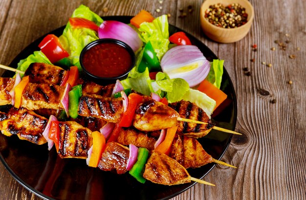 Kebab on wooden stick with fresh salad.