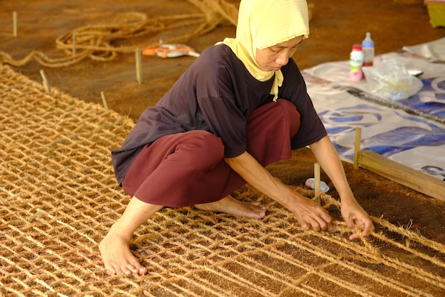 Kebumen, Indonesia. September 5, 2022. coconut coir rope craftsmen are weaving coconut coir ropes.