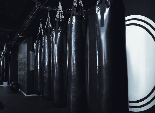 Сохраняйте спокойствие и боксируйте на натюрморте с рядом боксерских груш в спортзале