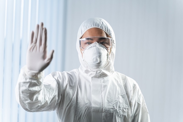 Keep calm. Competent medical worker raising his hand and looking at camera, science and research concept