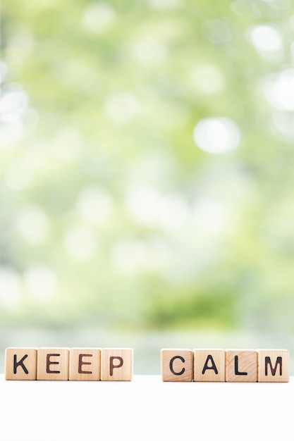 写真 keepcalmの単語は緑の夏の背景に木製の立方体に書かれています木製の要素のクローズアップ