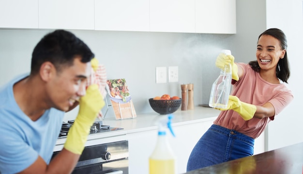 Keep it light fresh and fun Shot of a young couple taking a break from cleaning to play around