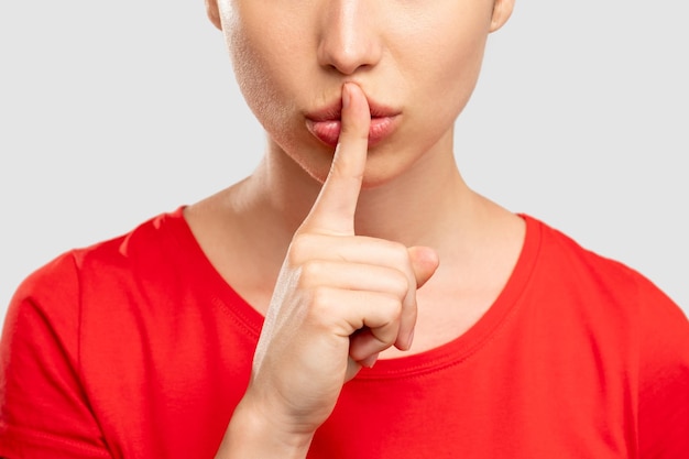 Keep secret silence gesture close up woman