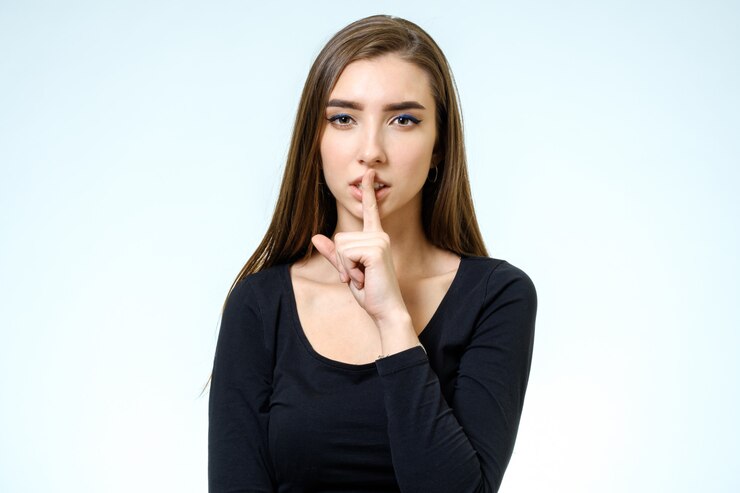 Photo keep silence! beautiful young woman holding finger on lips