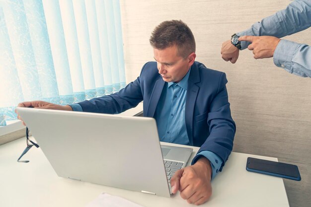 Tieni traccia del tempo uomo all'orologio orario di lavoro o orario di lavoro gestione del tempo vita in ufficio tempo per il lavoro in ritardo al lavoro il capo rimprovera il dipendente per essere in ritardo o per la scadenza del lavoro in ritardo