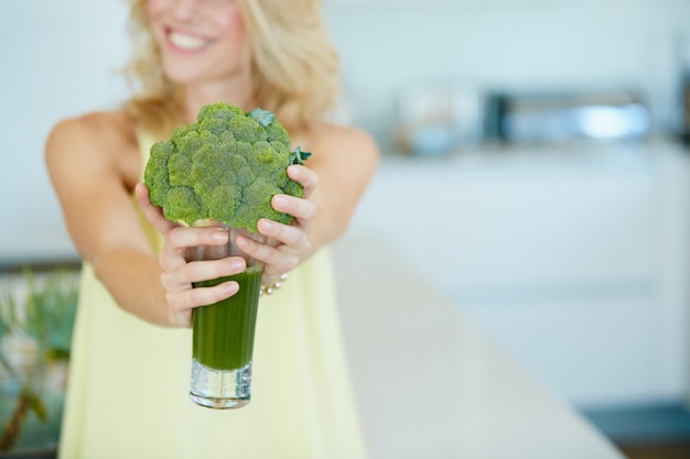 Mantieni il tuo corpo felice con uno di questi scatto di una donna felice con in mano un frullato di broccoli