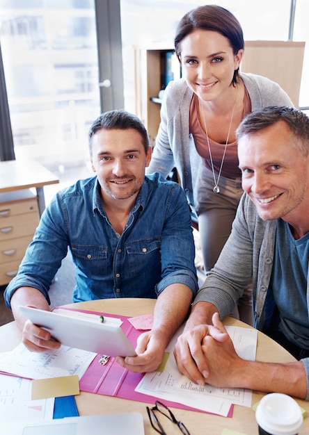 Keeping up with digital trends Portrait of three coworkers in a meeting using a tablet