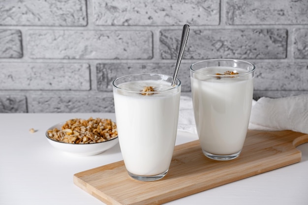 Kefir buttermilk or yogurt with granola Yogurt in glass on light background Probiotic cold