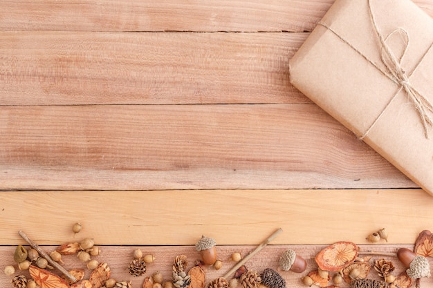 kegels, eikels en stukken hout met een verpakt pakket op een houten achtergrond