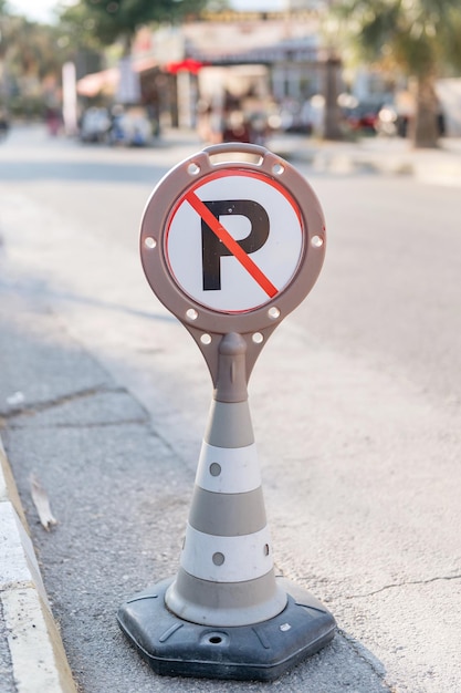 Kegelwaarschuwing over een parkeerverbod voor auto's en auto's. verkeersveiligheidsteken op de weg van de stadsstraat. gevaar waarschuwingssymbool op stedelijke manier voor auto's. besturen en regelen van het rijden in het stadspad